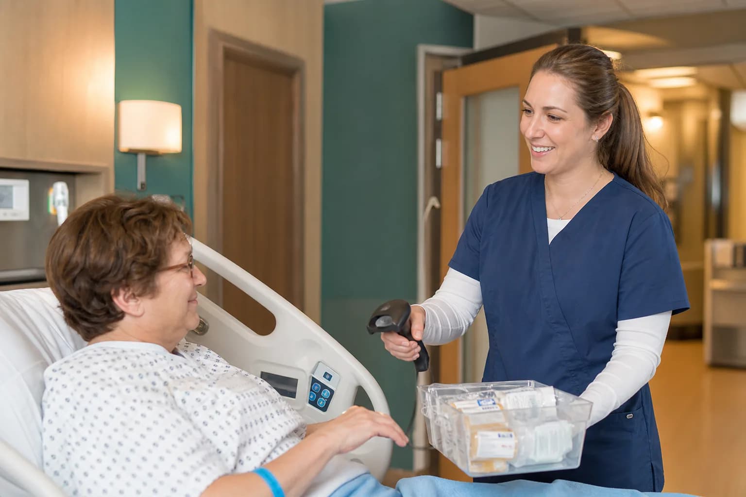 Inpatient pharmacy technician assembling patient-labelled unit dose trolleys for a ward round